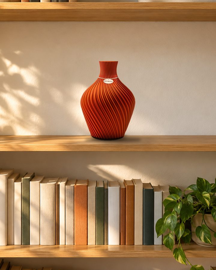 A Sunlit Terracotta Aro vase alone on a bookshelf with space around it